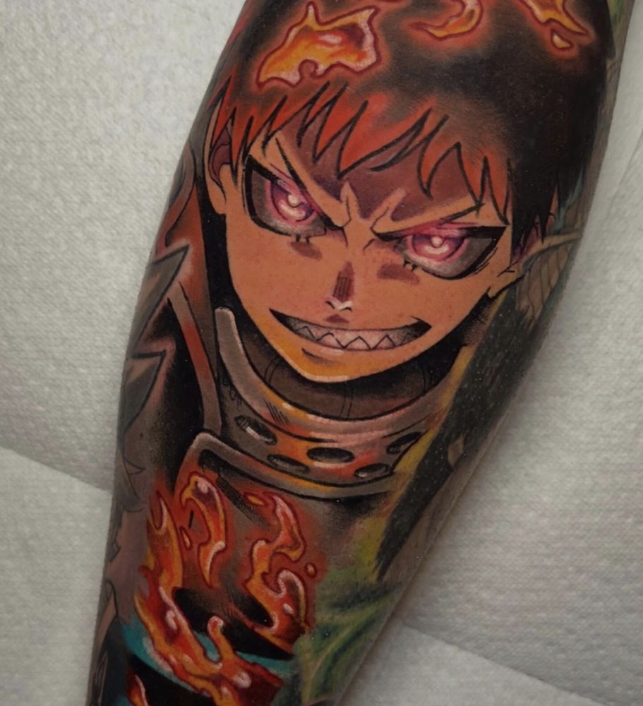 Anime tattoo of Shinra Kusakabe from Fire Force, grinning with glowing eyes
